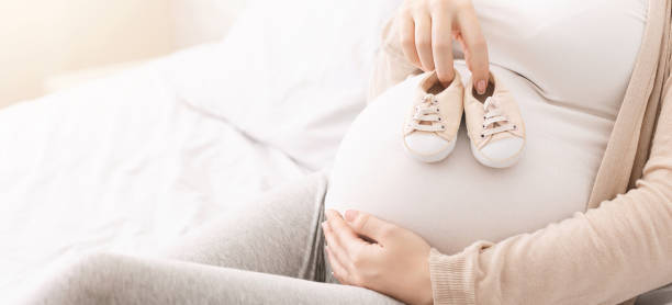 scarpe piccole per nascituro sulla pancia della donna incinta - bedroom accessories foto e immagini stock