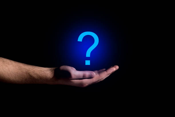 Hand showing a question mark in darkness
