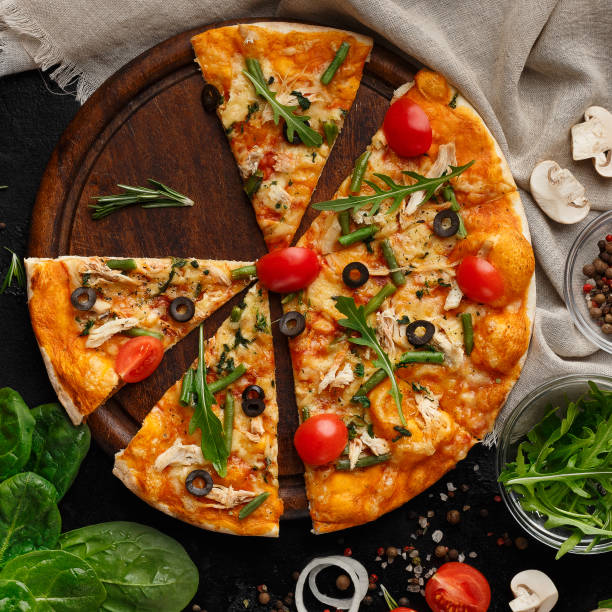 istock Sliced pizza with tomatoes and herbs on cutting board 1160221065