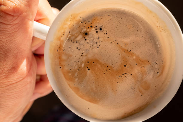 istock a man’s hand holding a white cup of hot coffee 1160221971