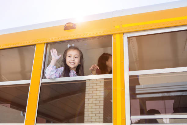 istock Adorable little girl waves from bus 1160223209
