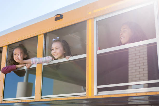istock Little girl waves from school bus 1160223211
