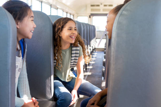 istock Three girls talking on school bus 1160223225