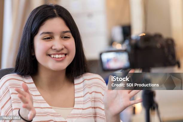 Teen Girl Smiles And Gestures While Filming With Digital Camera Stock Photo - Download Image Now