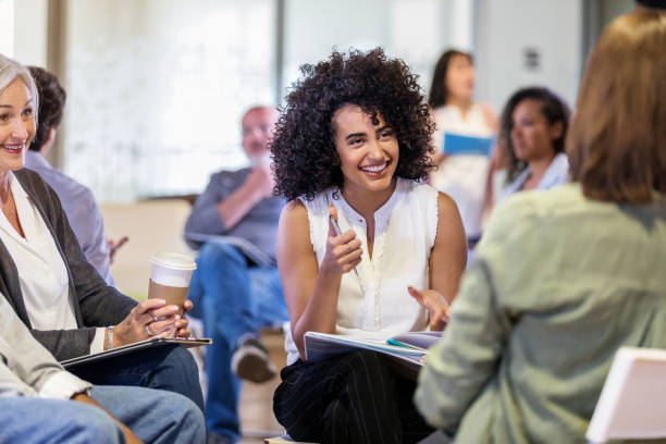 istock Smiling young woman facilitates discussion group 1160223351