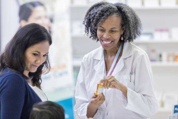 istock Cheerful pharmacist discusses medicine with young customer 1160223492
