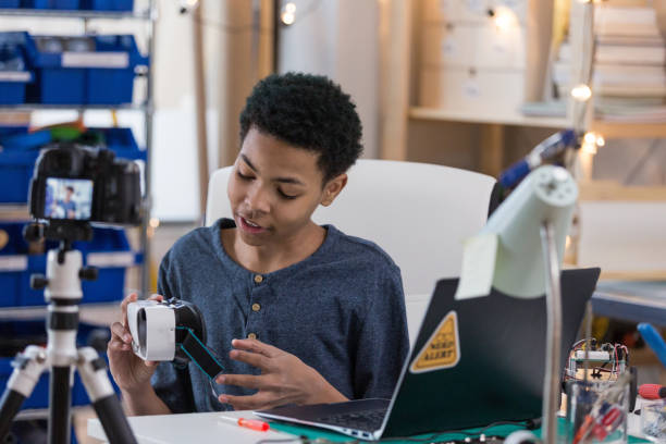 istock Teenager examines VR goggles during vlog 1160223538