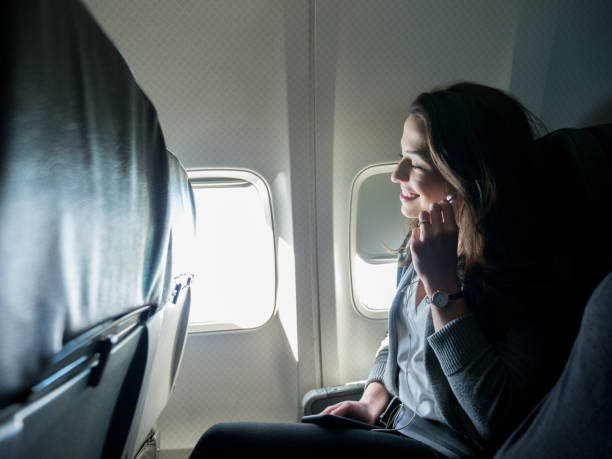 istock During flight, young woman inserts earbuds for audio book 1160223615