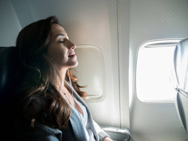 istock Young woman relaxes and sleeps mid flight 1160223645
