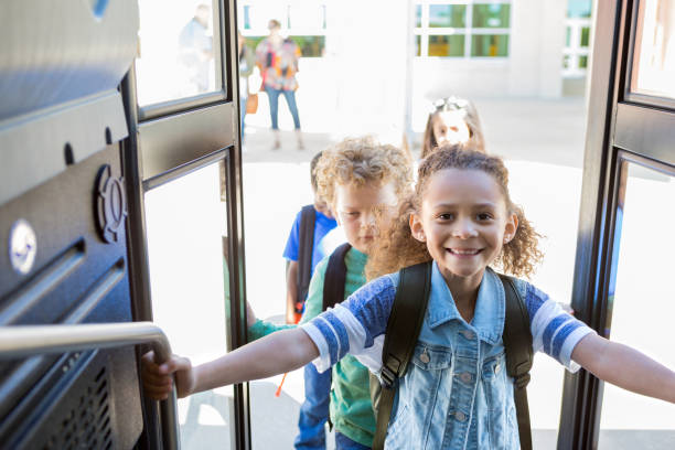 los estudiantes de la escuela primaria ansiosos y felices abordan el autobús - bus door fotografías e imágenes de stock