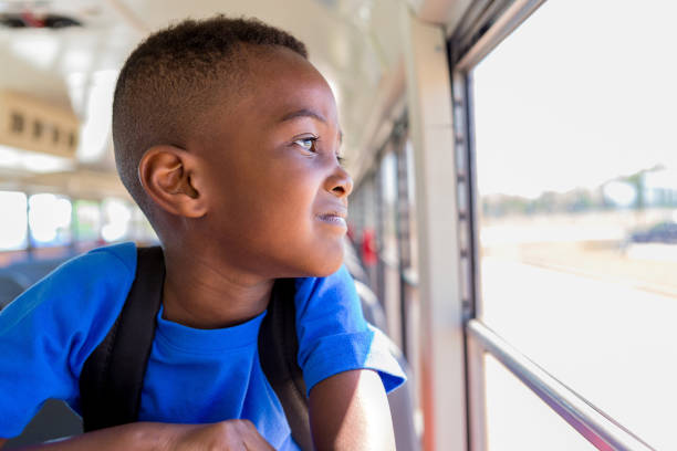 istock Young boy worries looking out at school from bus window 1160223680