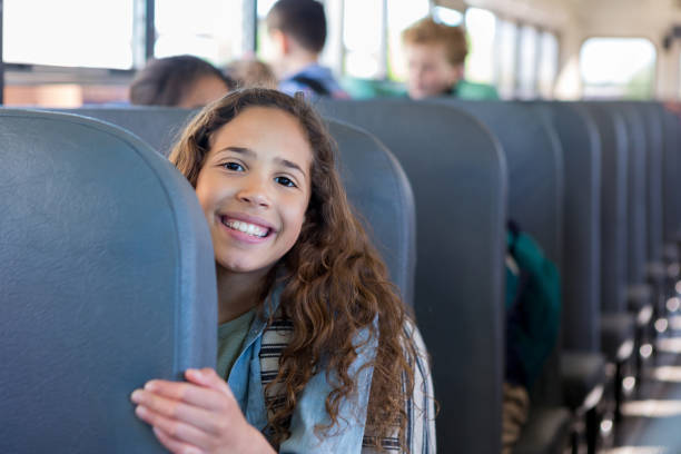 istock Elementary age girl sits on bus seat and smiles 1160223690