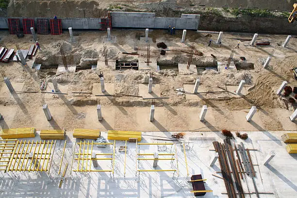 Birds eye view at foundation trench with columns and other building materials