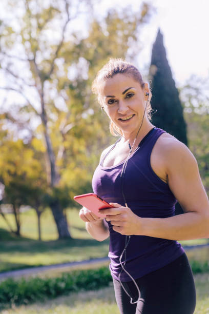 istock woman listening to music while preparing for run 1160225172