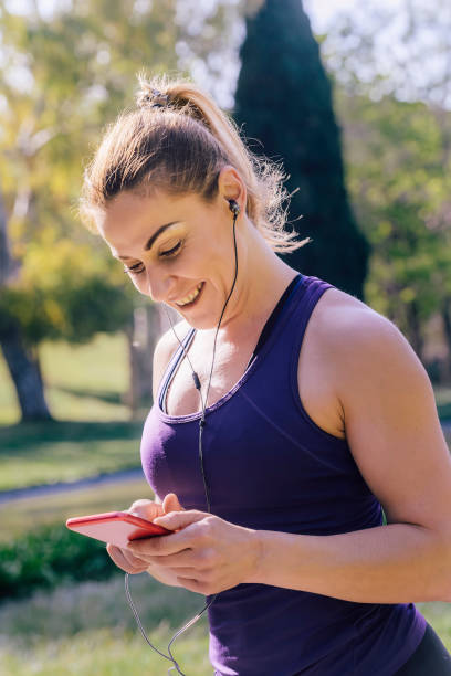 istock sporty woman setting up her music before running 1160225183