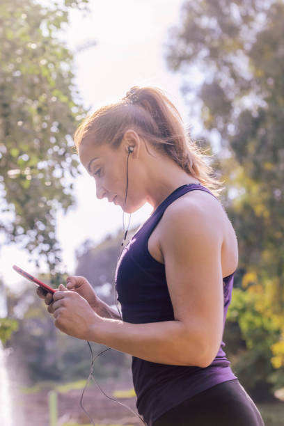 istock sports woman checking her phone app before running 1160225192