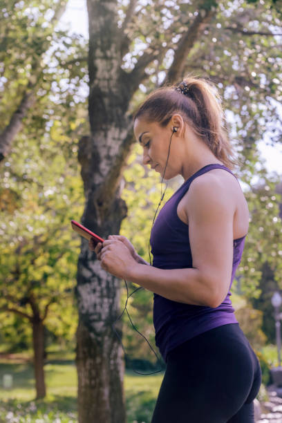 istock sporty woman checking her phone app before running 1160225195