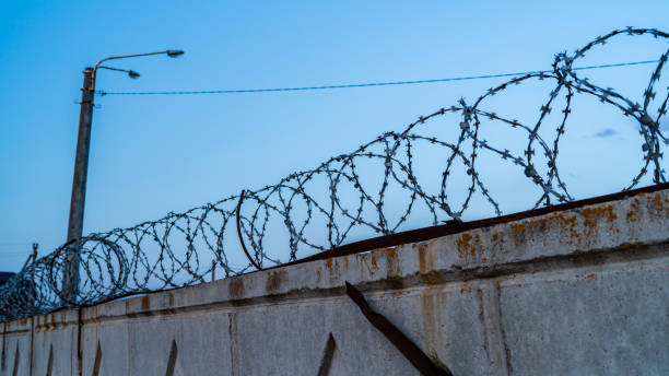 istock barbed wire on the fence, territory security 1160227025