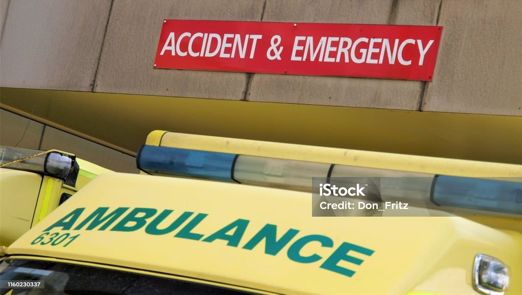 The top of an NHS ambulance cab showing the ambulance sign below a sign saying accident and emergency An ambulance waiting outside an NHS hospital in Poole, Dorset, UK underneath an accident and emergency sign on the overhang UK Stock Photo