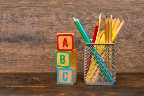 lettres d'abc peintes sur des blocs en bois et des crayons colorés dans le panier - fall semester photos et images de collection