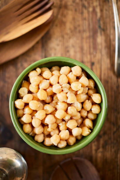 Vegan food, bowl of chick peas on a wooden table. Lifestyle vegan diner chickpea stock pictures, royalty-free photos & images