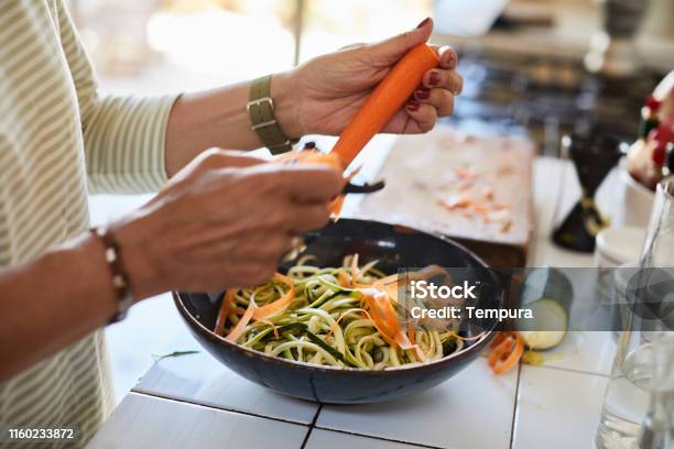 Vegan Food Closeup Of Hands Pealing A Carrot Making A Salad Stock Photo - Download Image Now