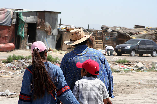 Poverty A family is walking to their home at a garbage dump. family mother poverty sadness stock pictures, royalty-free photos & images