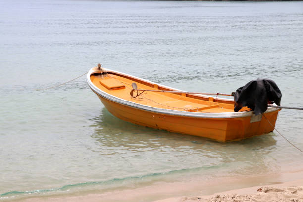 The yellow boat is parked on the beach.