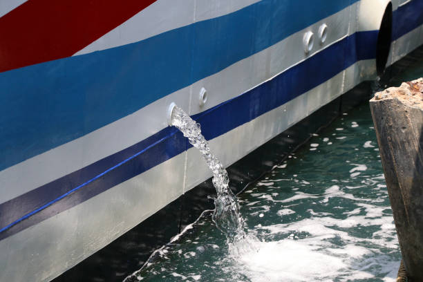 água que foi bombeada para fora do barco enquanto estacionava no cais. - pumped - fotografias e filmes do acervo