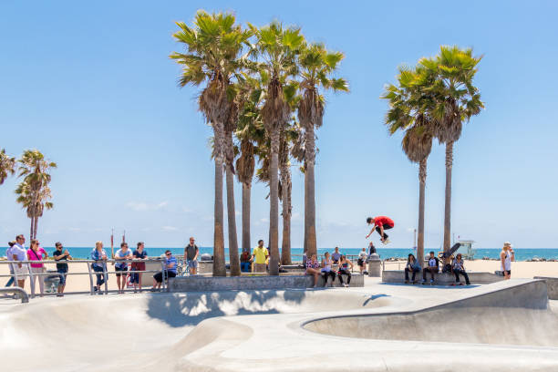 menino do skater que pratica no parque do patim na praia de veneza, los angeles, califórnia. venice beach é uma das praias mais populares de la county - palm tree california city of los angeles venice beach - fotografias e filmes do acervo