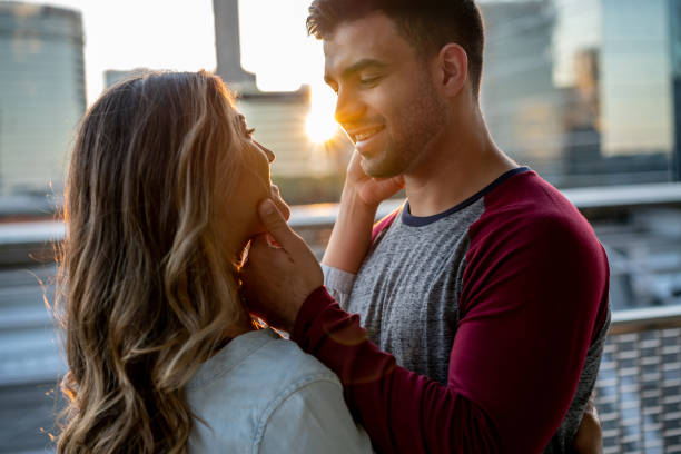 istock Affectionate young couple caressing their face while standing at a penthouse terrace smiling 1160238947