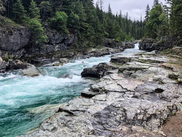 istock Aqua-colored water with white foamy waves along rocky shore 1160239992