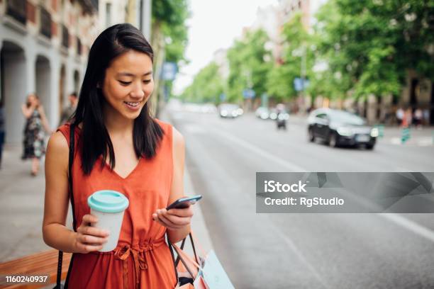 Young Woman Walking On The Street Stock Photo - Download Image Now - People, Women, Using Phone