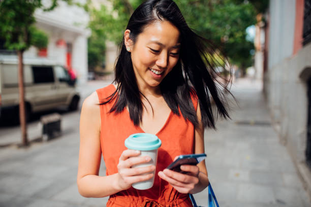 istock Young woman on street using smartphone 1160240938
