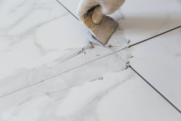 istock Grouting tiles seams with a rubber trowel. 1160244491