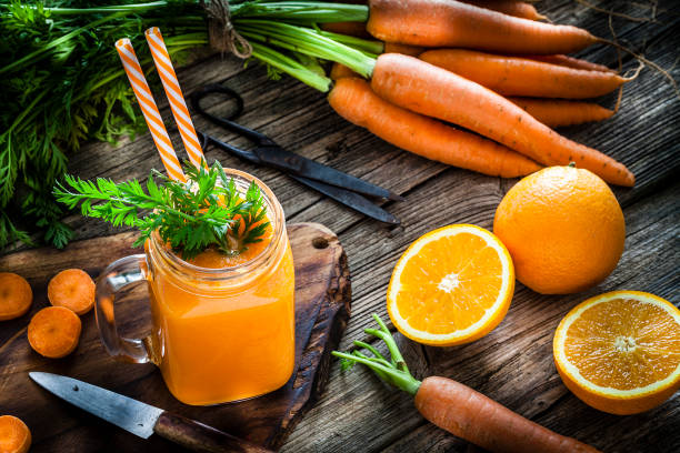 istock Healthy drink: orange and carrot juice on rustic wooden table 1160244834