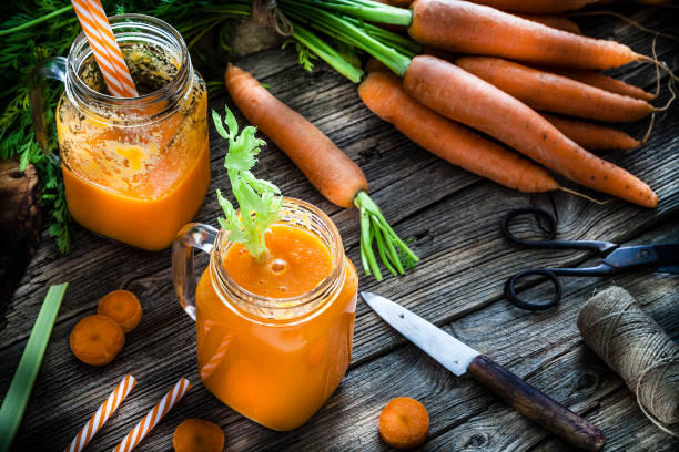 istock Healthy drink: carrot juice on rustic wooden table 1160244835