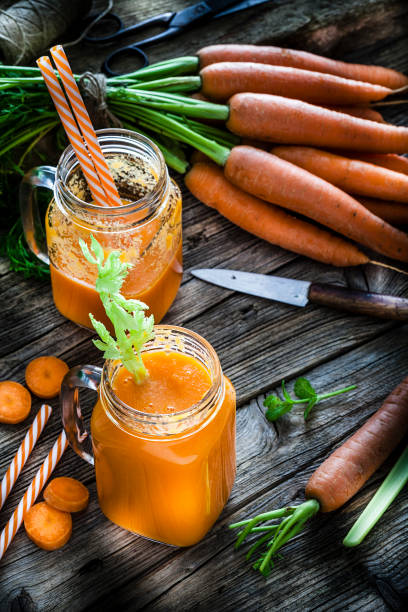 istock Healthy drink: carrot juice on rustic wooden table 1160244837