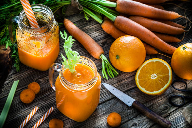 istock Healthy drink: orange and carrot juice on rustic wooden table 1160244844