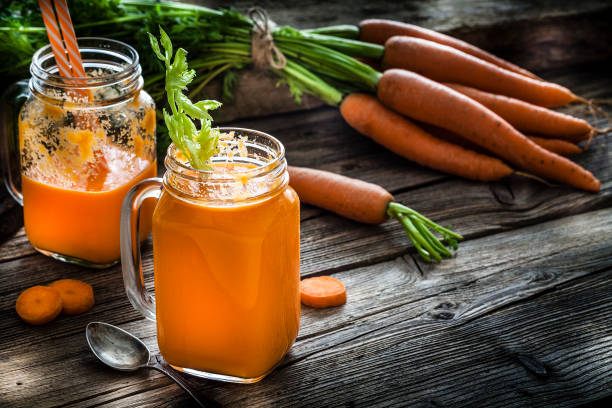 istock Healthy drink: carrot juice on rustic wooden table 1160244846