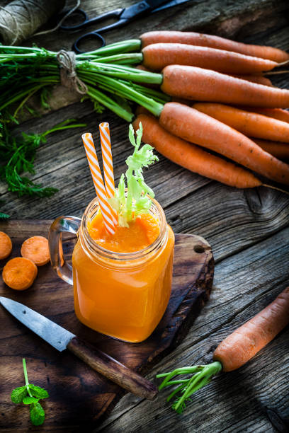 istock Healthy drink: carrot juice on rustic wooden table 1160244879