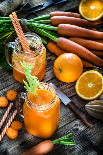 istock Healthy drink: orange and carrot juice on rustic wooden table 1160244882