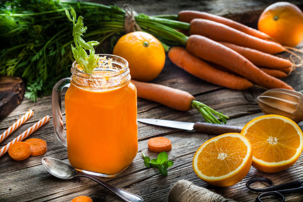 istock Healthy drink: orange and carrot juice on rustic wooden table 1160245878
