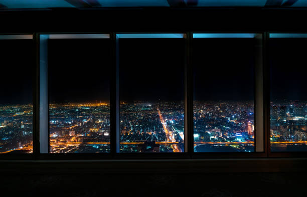 Aerial view of the Osaka skyline at night through a skyscraper window