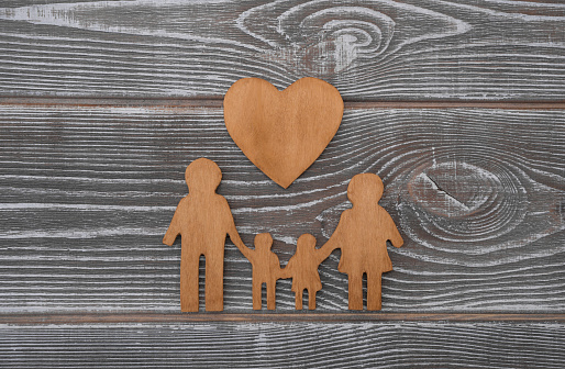family and heart shape made of wood on a wooden background