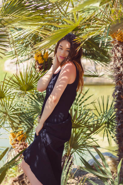 istock Woman relaxing under palm tree 1160253722