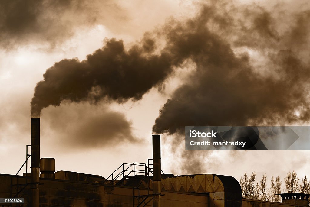 Industrial Revolution Dark smoke from an old factory. Industrial Revolution Stock Photo