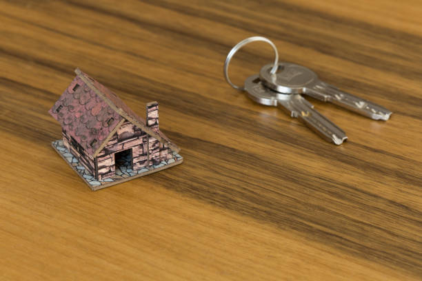 Keys and model house on wooden table. Real estate concept. Home buying and selling.