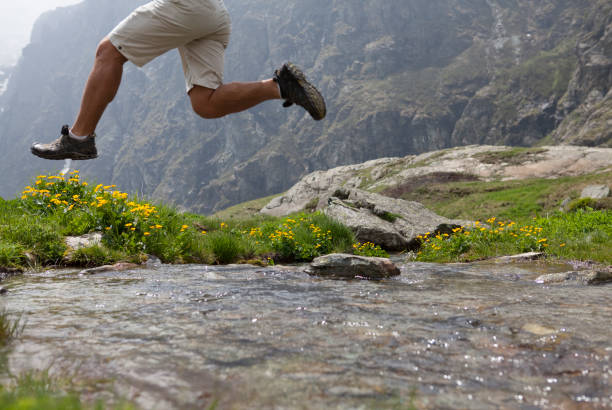 escursionista a mezz'aria salta su mountain creek - skill side view jumping mid air foto e immagini stock