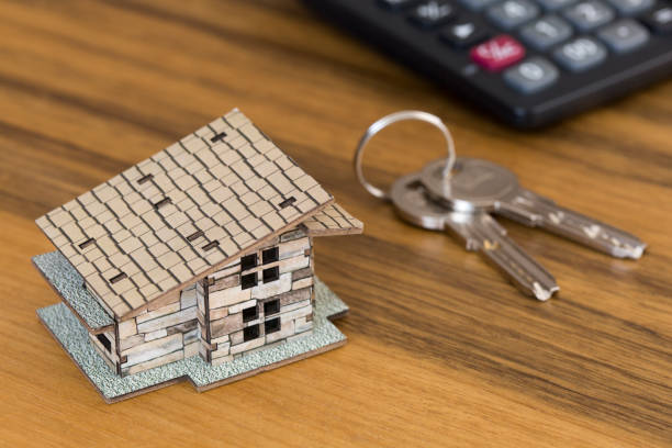 istock Keys, model house and calculator on wooden table 1160259475